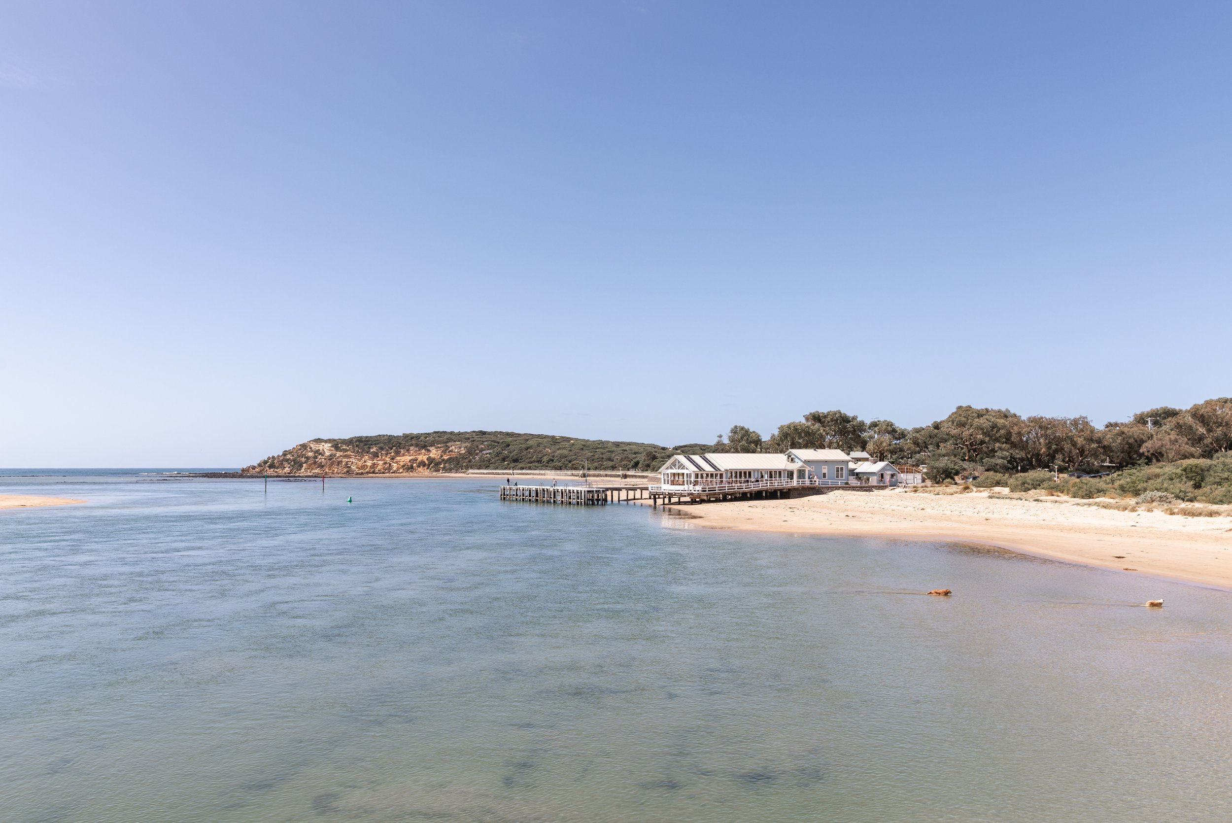 Image of The Heads Restaurant taken from the Barwon Heads Bridge. Includes the Bluff in the background